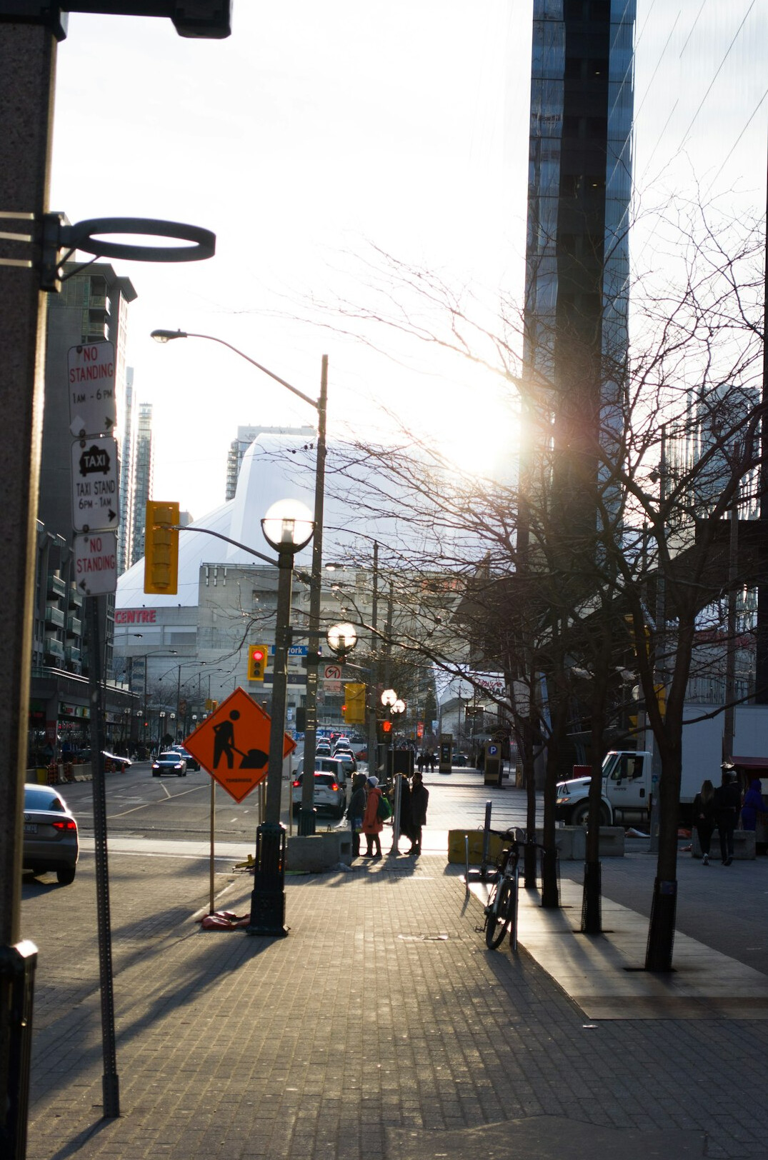 Busy downtown Toronto street with pedestrians at golden hour